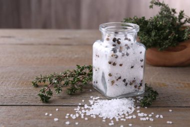 Cam kavanozda biberli tuz ve ahşap masada kekik, metin için boşluk.