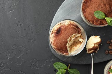 Bardakta, kaşıkta, nane yapraklarında ve kahve çekirdeklerinde nefis tiramisu. Metin için boşluk