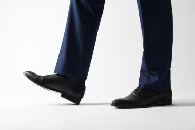 Beyaz arka planda deri ayakkabılı iş adamı, yakın plan.