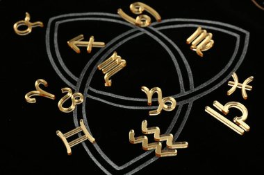 Golden zodiac signs on dark background, closeup clipart
