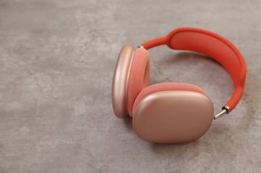 Açık gri masada pembe kulaklıklar, yakın plan. Metin için boşluk