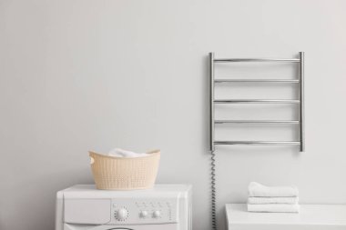 Banyodaki beyaz duvarda ısıtmalı havlu parmaklığı, mesaj için yer