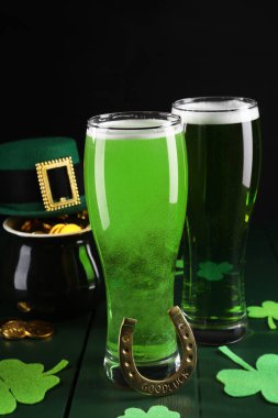 St. Patrick 'in gündüz partisi. Yeşil bira, leprikon şapka, bir küp altın, at nalı ve ahşap masa üzerindeki dekoratif yoncalar.