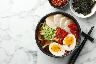 Beyaz mermer masada servis edilen ramen tabağındaki leziz ramen, yazı için yeri olan bemol. Erişte çorbası.