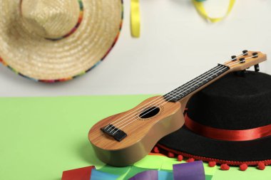 Siyah Flamenko şapka ve ukulele yeşil masada, yakın plan. Metin için boşluk