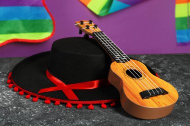 Siyah Flamenko şapka ve ukulele koyu dokulu masa, yakın plan.