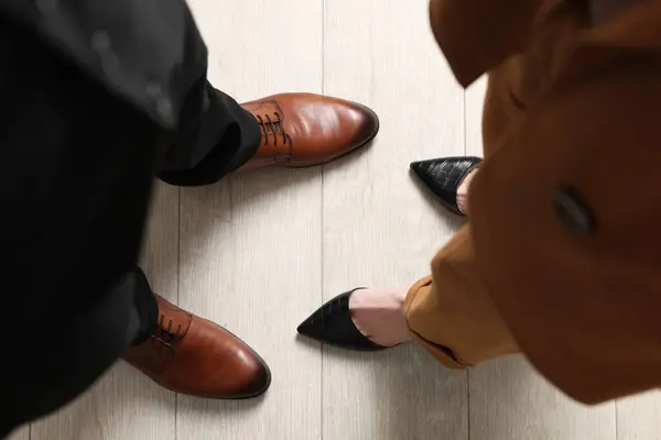 Businessman and businesswoman in elegant shoes on floor, above view