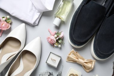 Düğün şeyleri. Açık gri arka planda şık yaka çiçeğiyle düz bir kompozisyon.