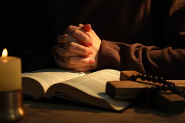 Masada yanan mum ve İncil 'le dua eden kadın, yaklaş.