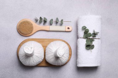 Gri masa üzerinde spa ürünleri ve okaliptüs dalları ile düz bileşim yatıyordu