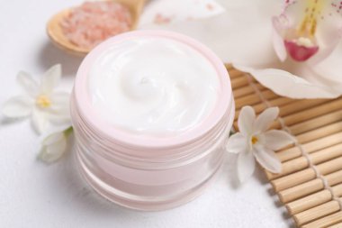 Beyaz masa üzerinde kozmetik ürünleri ve çiçekleri olan güzel bir spa kompozisyonu