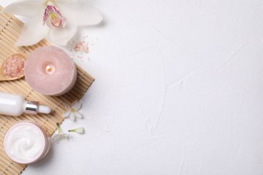Beyaz masa üzerinde kozmetik ürünleri ve çiçekleri olan güzel bir spa kompozisyonu. Metin için boşluk