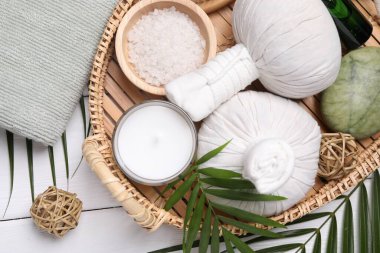 Beyaz ahşap masa üzerinde mum ve farklı spa ürünleri ile düz bileşim yatıyordu