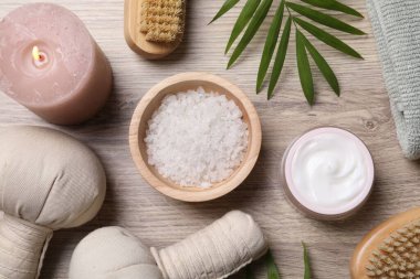 Spa ürünleri ve hafif ahşap masada yanan mum ile düz bileşim yatıyordu