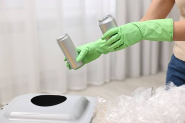 Çöp ayıklama. Odamdaki çöp kutusuna metal kutular atan kadın, yakın plan.