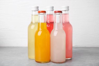 Gri masadaki cam şişelerde beyaz arka planda nefis kombu çayı