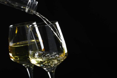 Siyah arka planda cama lezzetli aromatik şarap dökmek, yakın plan. Metin için boşluk