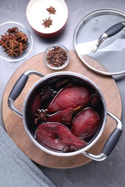 Lezzetli kırmızı şarap haşlanmış armut ve baharatlar gri masada, düz yatıyordu.