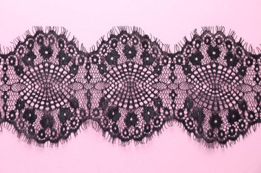 Pembe arka planda siyah dantel, üst görünüm