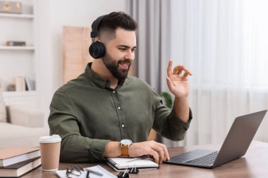 E-öğrenme. Genç adam çevrimiçi ders sırasında bilgisayar kullanıyor.