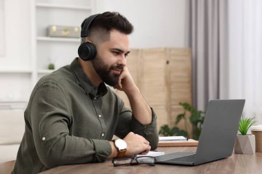 E-öğrenme. Genç adam çevrimiçi ders sırasında bilgisayar kullanıyor.