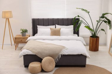 Büyük yatak odası, lamba ve çiçek desenli.