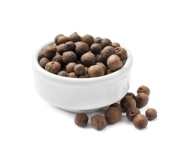 Beyaz kasede izole edilmiş tüm baharat meyveleri (Jamaika biberi).