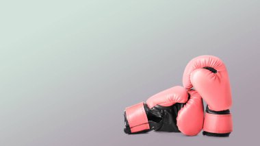 Göğüs kanseri farkındalığı. Açık gri arka planda bir çift pembe boks eldiveni, mesaj için yer. Pankart tasarımı