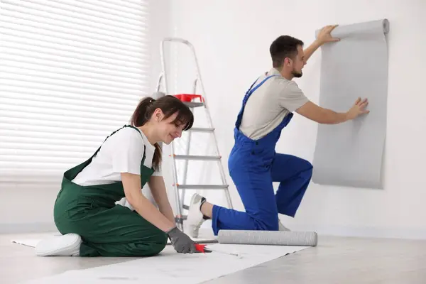 남자가 실내에서 시트를 걸고있는 벽지에 접착제를 적용하는 — 스톡 사진