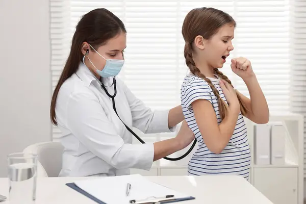 病院で咳をする女の子を診察する医師 冷たい症状 ストックフォト
