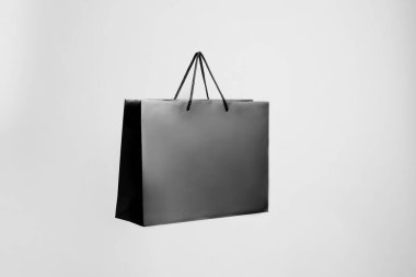 Gri arkaplanda bir siyah kağıt alışveriş çantası