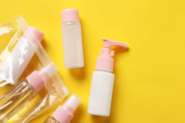 Sarı zemin üzerinde kozmetik seyahat seti olan plastik torba, düz. Metin için boşluk