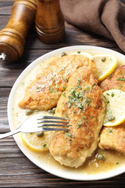 Delicious chicken piccata on wooden table, closeup clipart