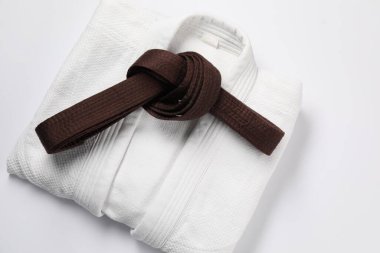 Kahverengi karate kemeri ve beyaz arka planda kimono, üst görünüm