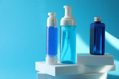 Açık mavi arka planda lüks kozmetik ürünleri. Metin için boşluk