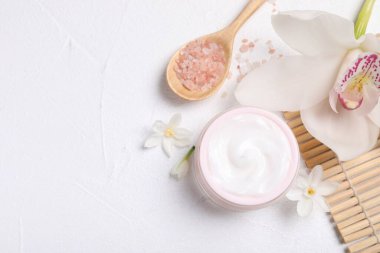 Beyaz masa üzerinde kozmetik ürünleri ve çiçekleri olan güzel bir spa kompozisyonu. Metin için boşluk