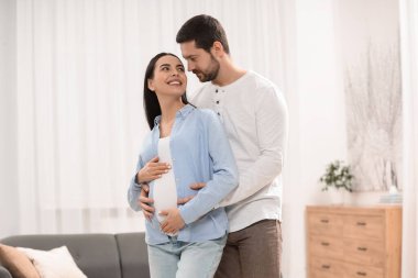 evde kocasıyla mutlu hamile kadın