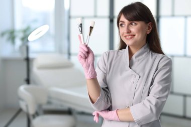 Klinikte kozmetik fırçası olan kozmetik bilimci, metin için yer