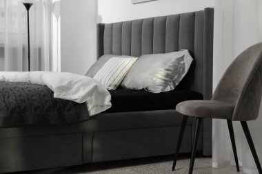 Büyük yatak odası, lamba ve sandalye.