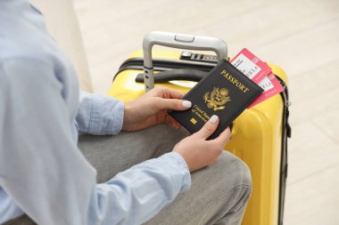 Bavullu kadın, pasaport ve arka planı bulanık biletler, yakın plan.