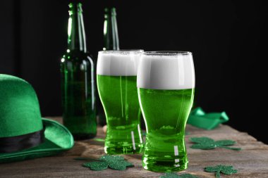 St. Patrick 'in gündüz partisi. Yeşil bira, dekoratif yonca yaprakları ve ahşap masada leprikon şapka.