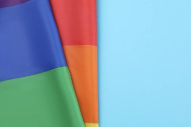 Açık mavi arka planda gökkuşağı LGBT bayrağı, üst manzara. Metin için boşluk