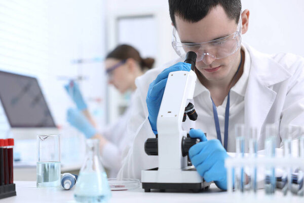 Scientist working with microscope in laboratory. Medical research