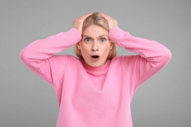 Gri arka planda şaşırmış kadın portresi