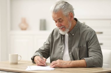 Son sınıf öğrencisi içeride masada vasiyetnameyi imzalıyor. Metin için boşluk