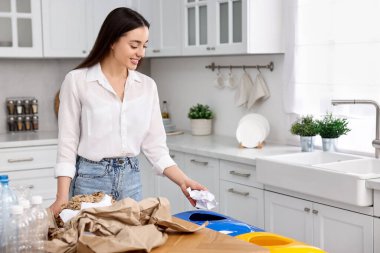 Mutfakta çöpleri ayıran gülümseyen kadın. Metin için boşluk