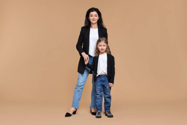 Bej arka planda küçük kızı olan güzel bir anne.
