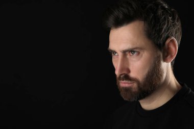 Kem göz. Siyah arkaplanda korkunç gözleri olan adam, yakın plan ve metin için boşluk