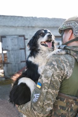 Ukraynalı asker sokak köpeğini kurtarıyor.