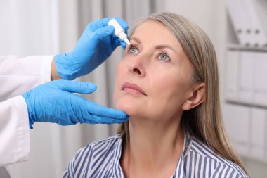 Tıbbi damlalar. Doktor içeride kadınların gözüne ilaç damlatıyor.